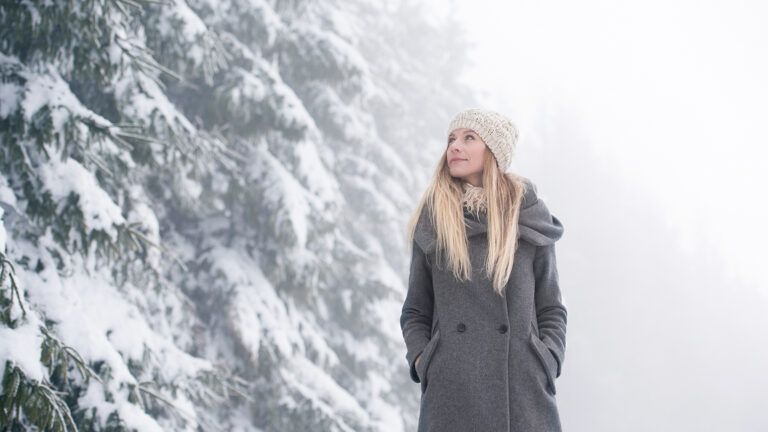 A woman looks heavenward on a winter afternoon