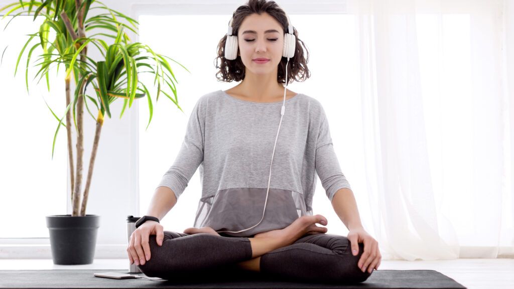 A woman meditating in her home.