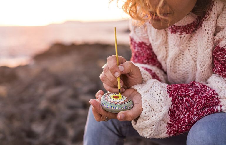 A woman painting a stone