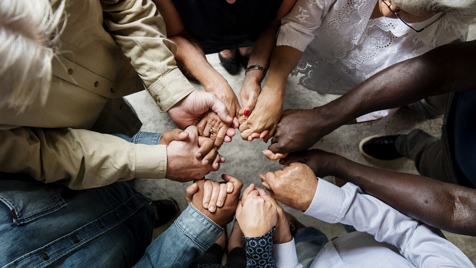 A group of people holding hands in a circle.