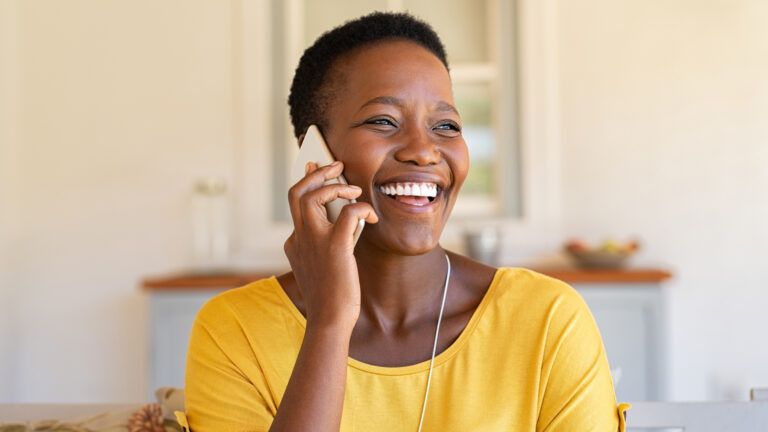 A woman happily talking on the phone.