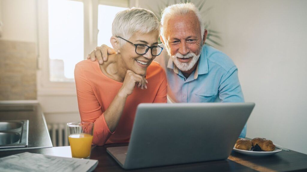 A man and woman video chat on a laptop