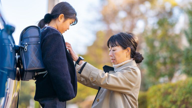 A mother gets her daughter ready for school.