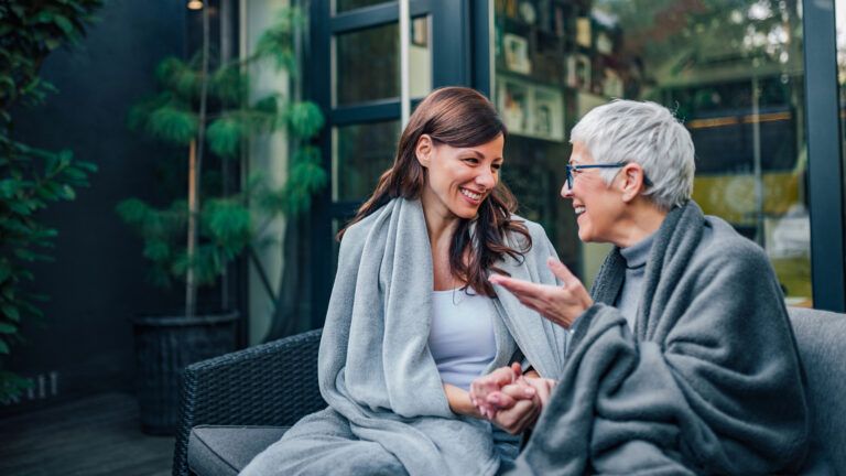 An aging mother having a conversation with her caregiver daughter.