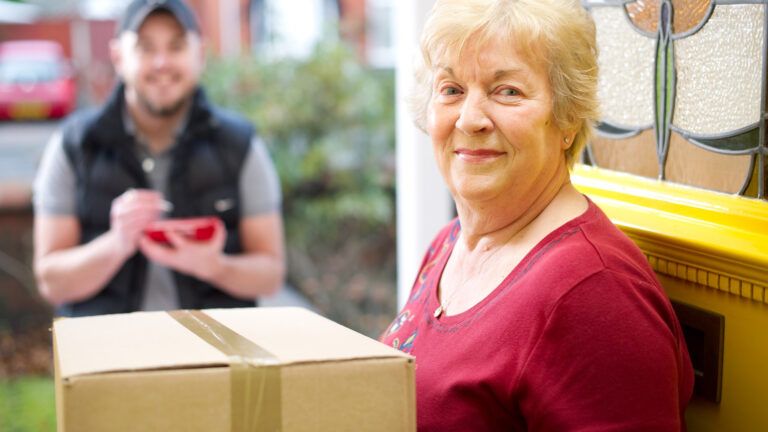 A delivery man conversing with a senior woman.