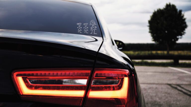 The back of a car with a family sticker on the rear window.