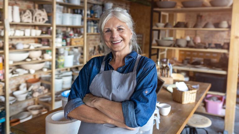 A smiling senior woman in her pottery studio