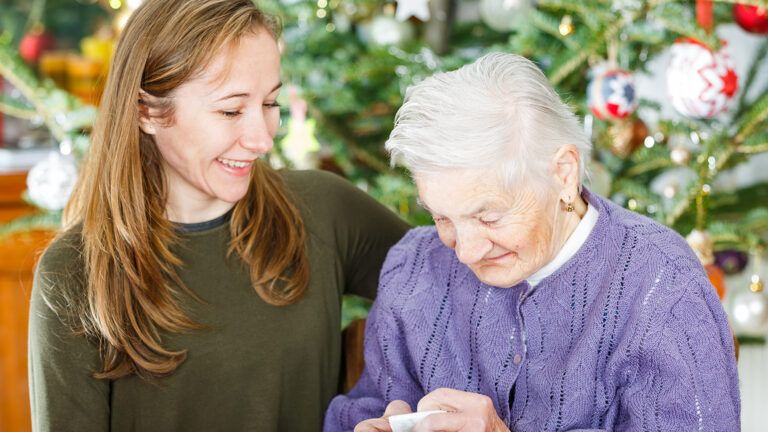 A young woman greets a senior woman at Christmas