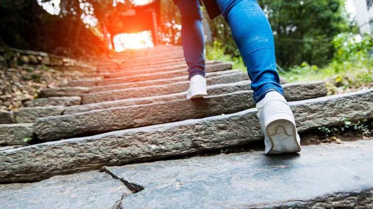 A woman jogs up a steep set of stairs