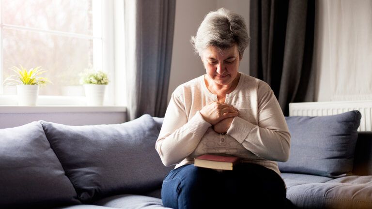 A woman prays over her Bible