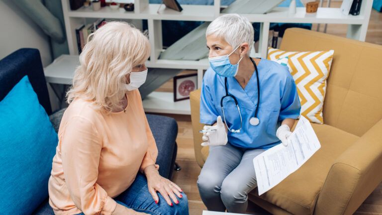 A woman having a conversation with a nurse; Getty Images