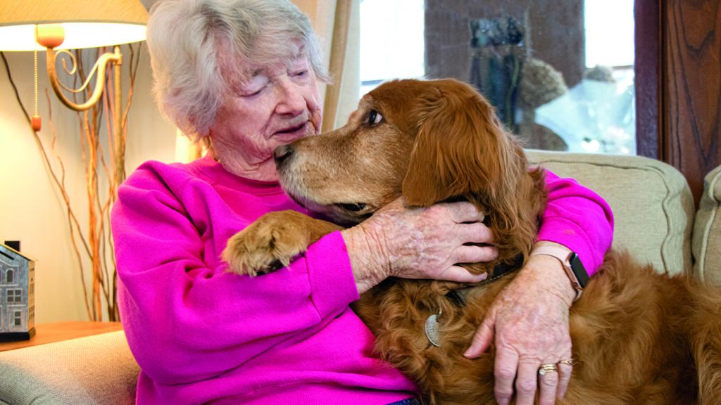 Senior cuddling with her dog