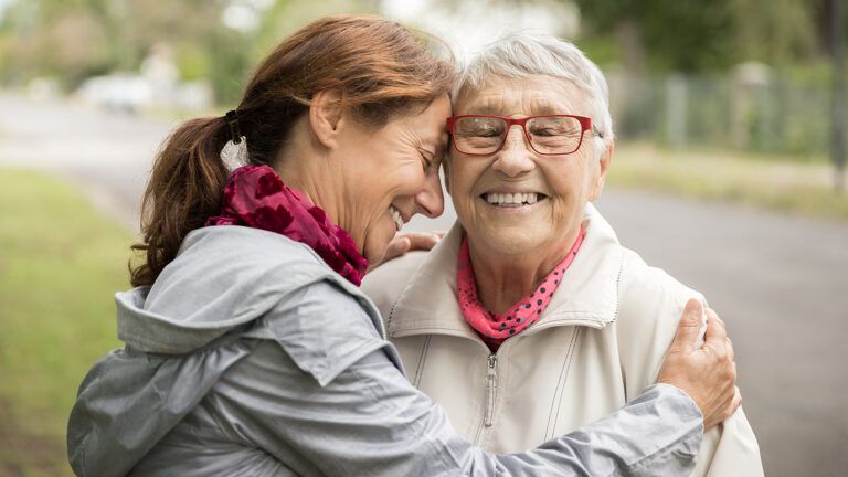 A caregiver embraces her mother