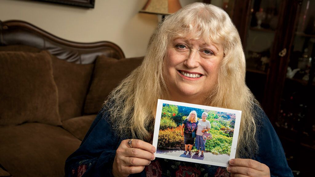 Kristy Dewberry holds a photo of herself and Carol; photo by Shevaun Williams