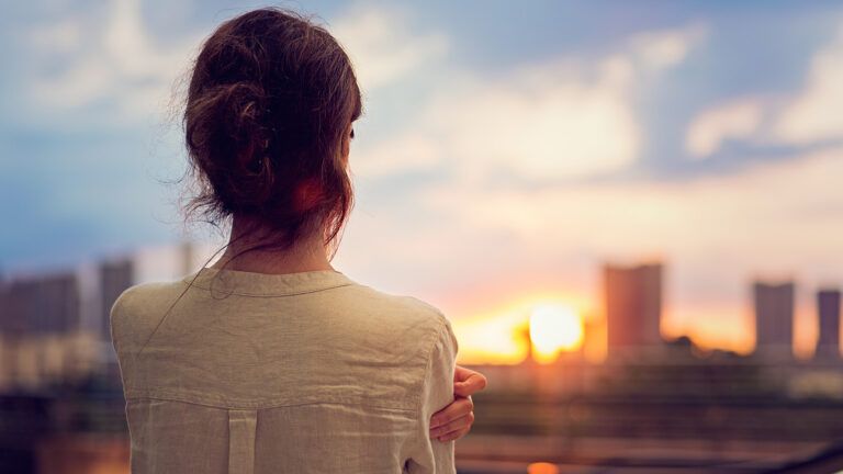 A woman gazes out at a cityscape