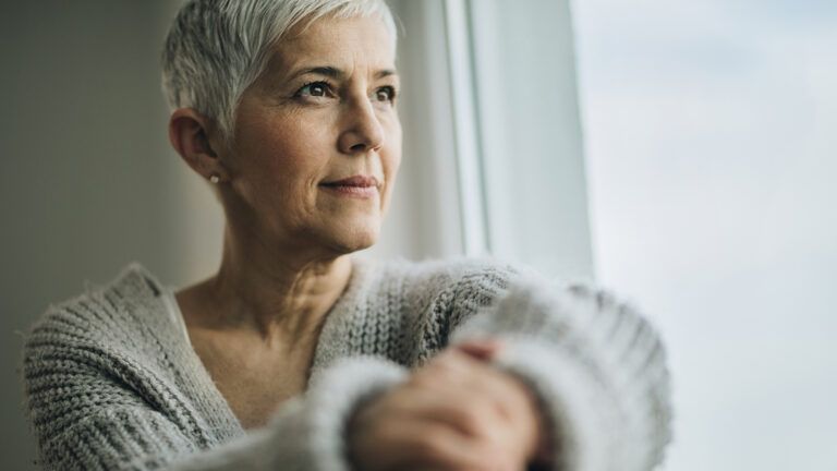 A contemplative woman gazes out the window