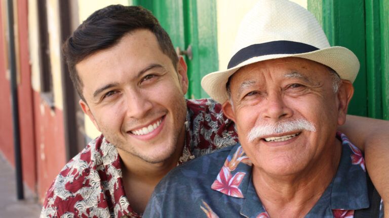 A senior man with his son smiling; Getty Images