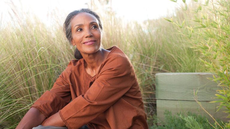 Serene woman sitting on grass