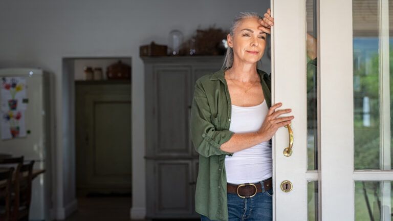 Thoughtful woman standing in her doorway