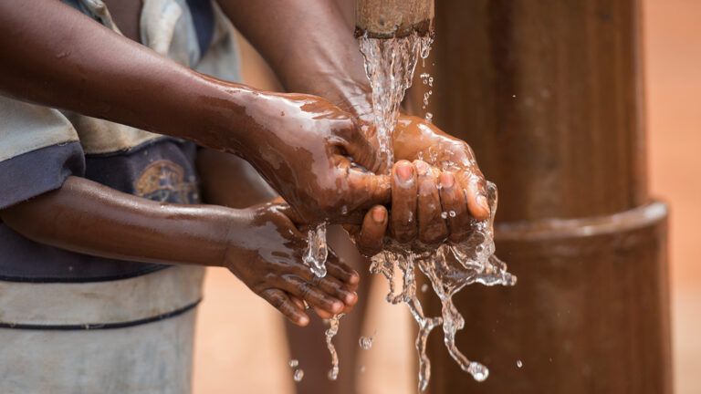 Hands thrust into flowing water