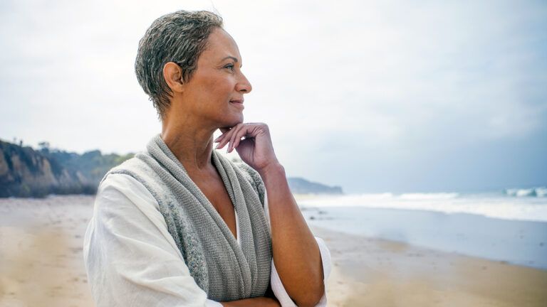 A contemplative woman gazes out at the beach