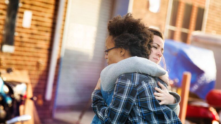 Two young women embrace in forgiveness