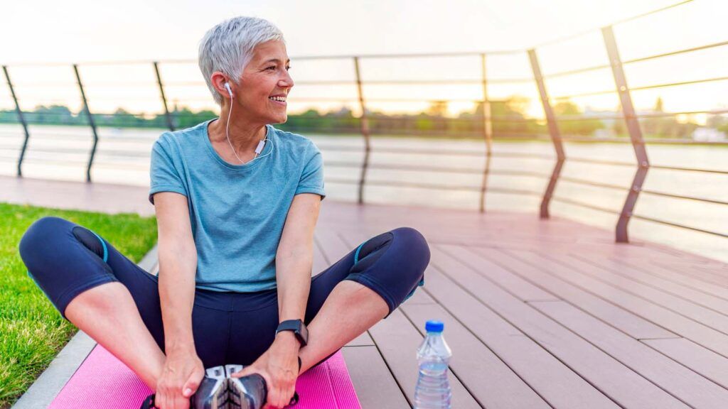 A woman doing morning stretches outdoors; Getty Images