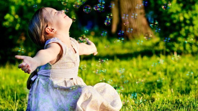 Little girl playing with bubbles