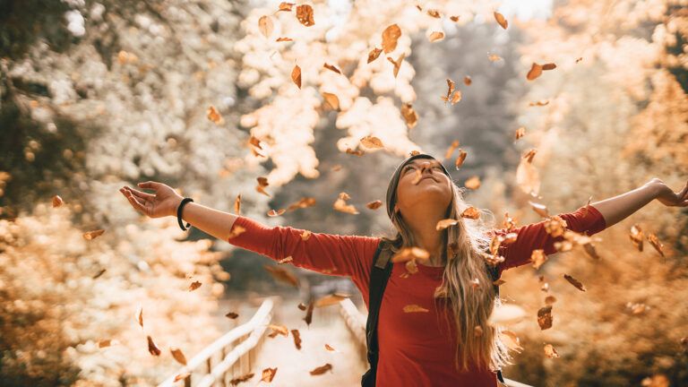 Woman surrounded by autumn leaves