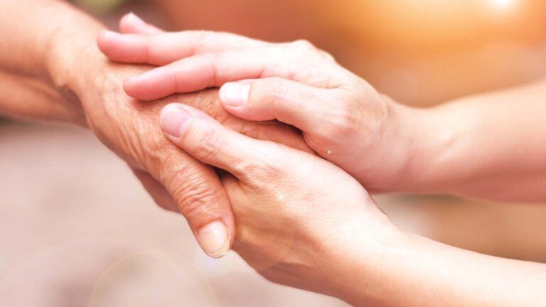 A pair of hands holding each other; Getty Images