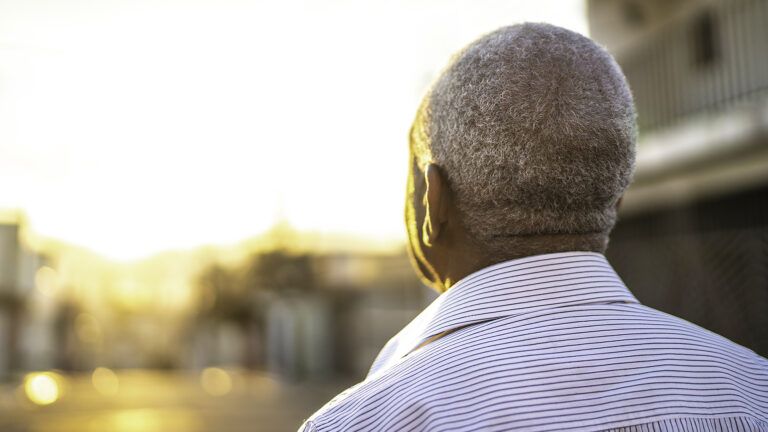 A senior man greets the sunrise