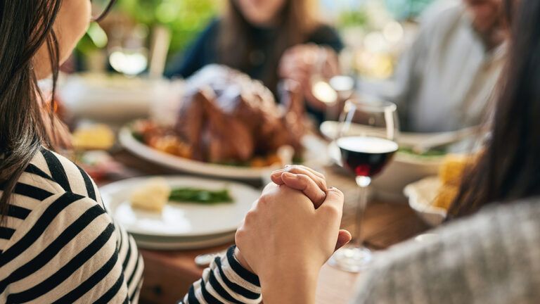 A family prays over Thanksgiving dinner