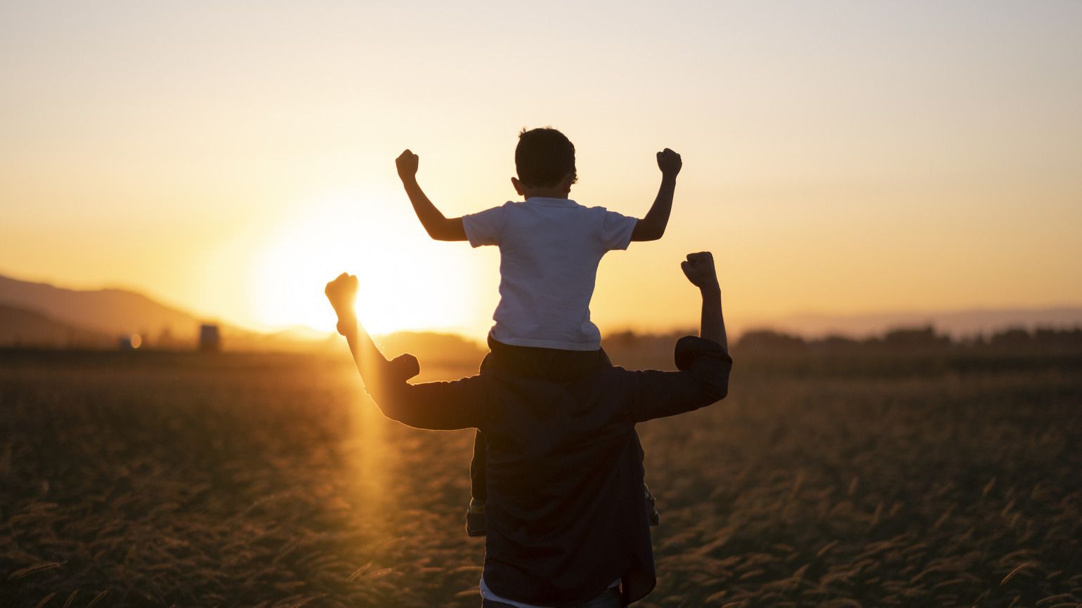 A father and son walking at sunset talking about God's hands