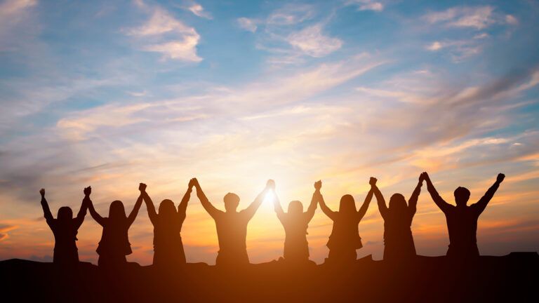 Group of people holding hands and praising