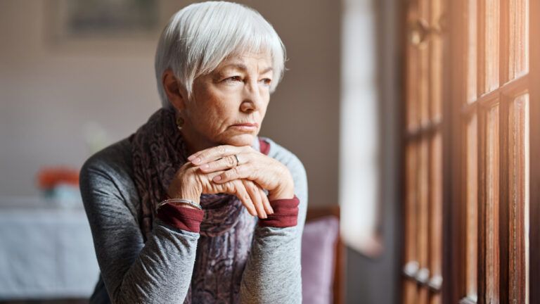 Worried woman staring out of a window