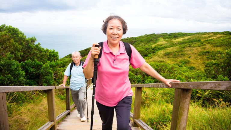 A man and a woman climb a steep path