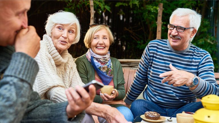 Senior friends having coffee outdoors