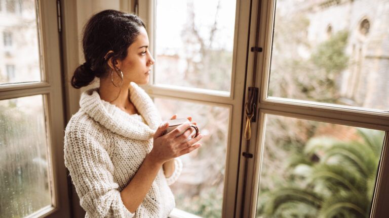 A contemplative woman gazes out the window