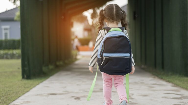 A young girl enters her elementary school