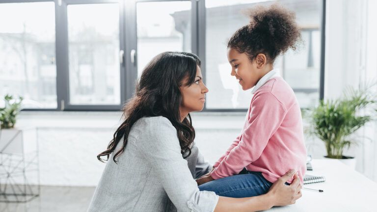 A mother converses with her young daughter