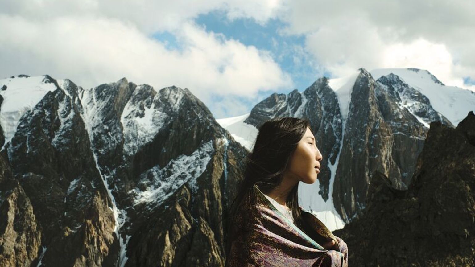 Woman in front of snow mountain doing positive living with an inspirational quote