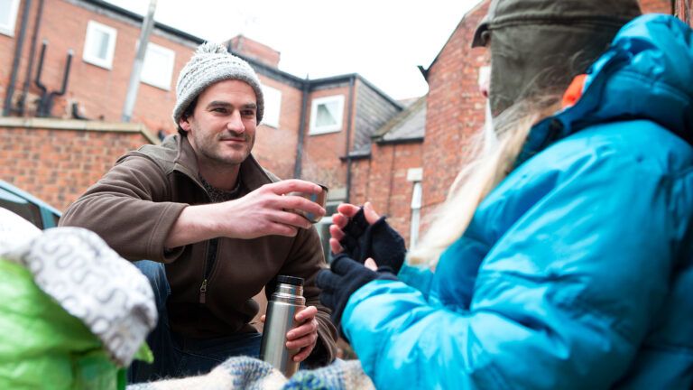 A man offers assistance to a homeless individual