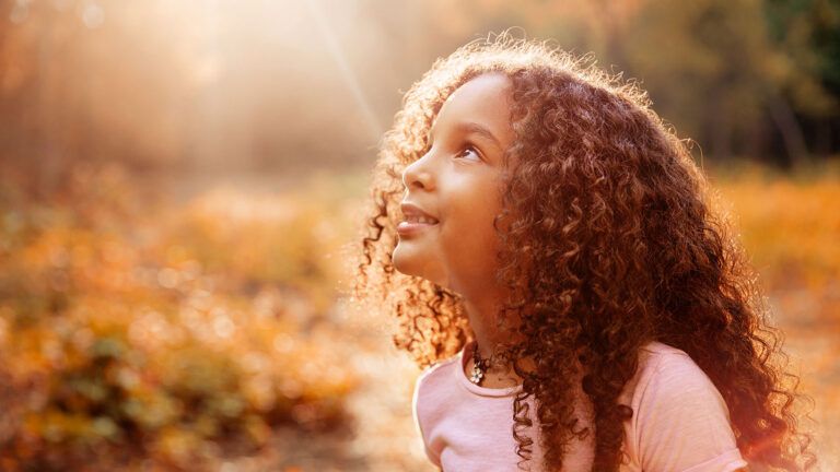 A young girl looks heavenward