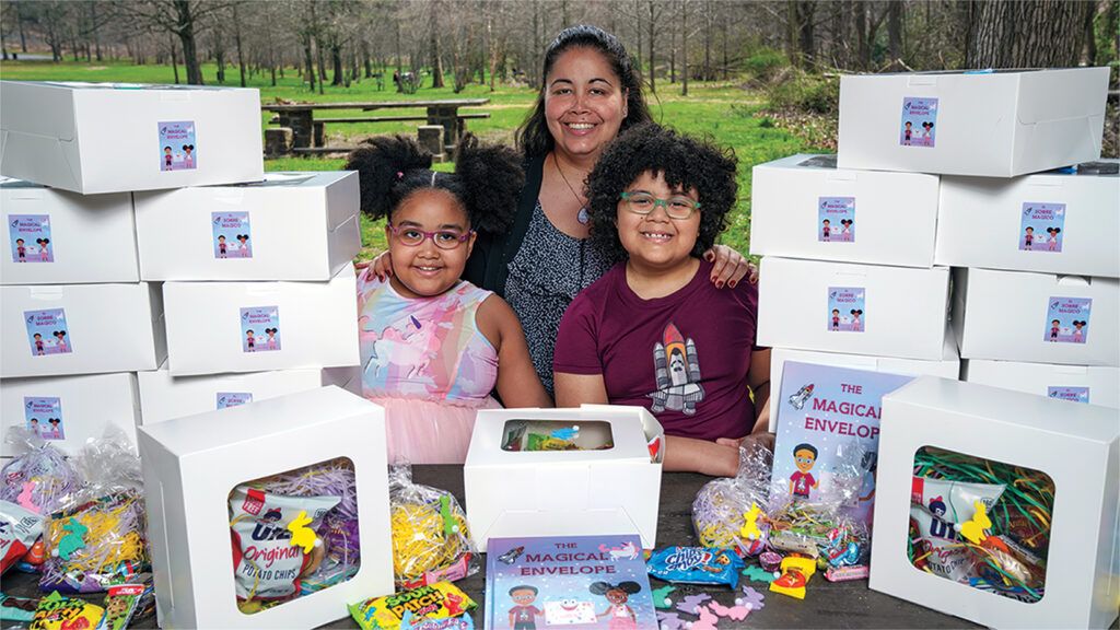 Miriam, Delilah and Nathenial Adams are surrounded by military care packages; photo by Todd Plitt