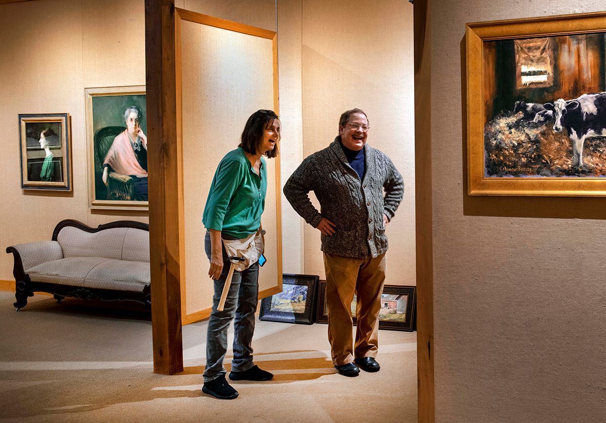 Inside the Brown County Art Guild where manager Roberta Chirko and a friend hang a painting; photo by Scott Goldsmith