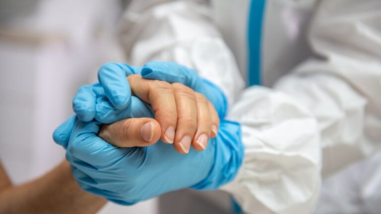 A nurse holding the hand of a patient