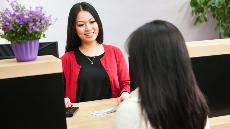 A bank clerk greets a customer