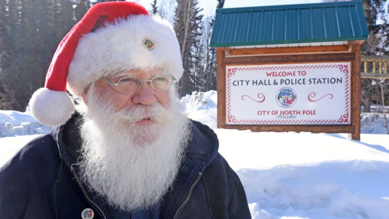 Mr. Claus in a Santa hat standing outside in the real North Pole