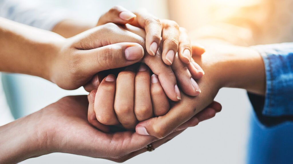 Hands holding each other during Lent; Getty Images