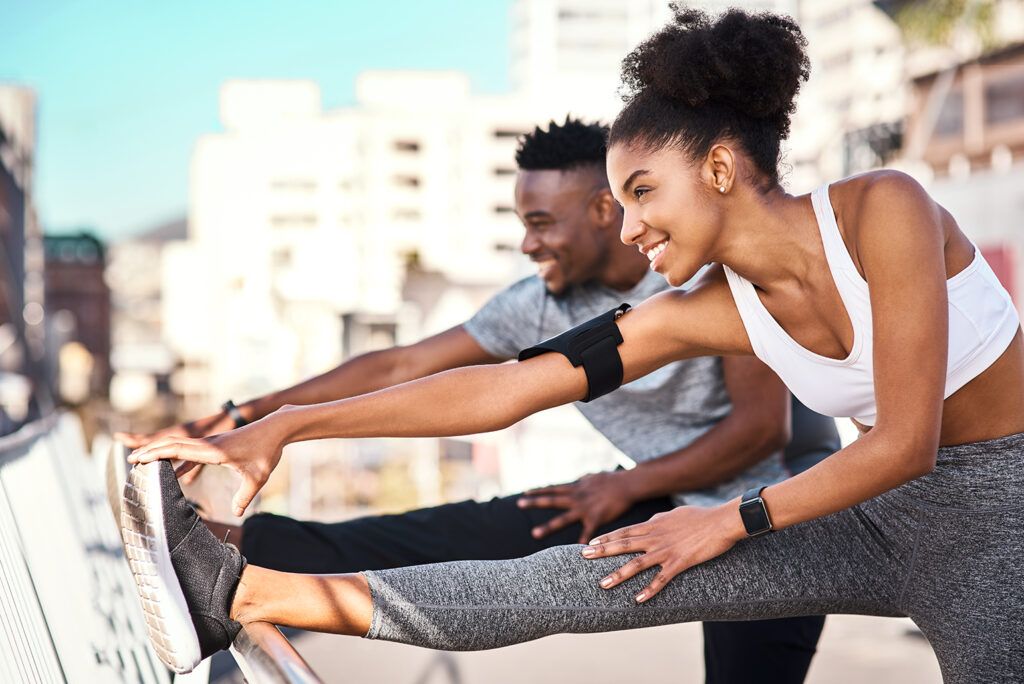 A young married couple stretches prior to exercising